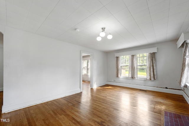 2715 E Geer St, Durham, NC 27704 - spare room with wood finished floors, arched walkways, and a smoke detector