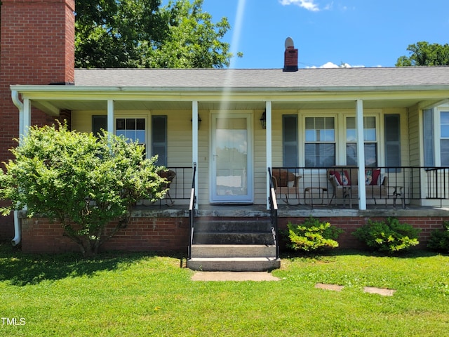 411 W Raleigh St, Siler City, NC 27344 - view of front of house with a chimney, a front lawn, and a porch