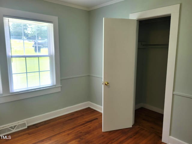 411 W Raleigh St, Siler City, NC 27344 - unfurnished bedroom featuring ornamental molding, dark wood finished floors, and a closet