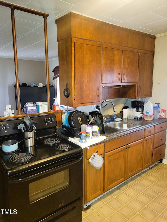 411 W Raleigh St, Siler City, NC 27344 - kitchen featuring electric range, brown cabinets, and light tile patterned floors
