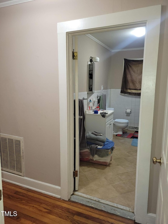411 W Raleigh St, Siler City, NC 27344 - bathroom featuring ornamental molding, tile walls, vanity, and a wainscoted wall