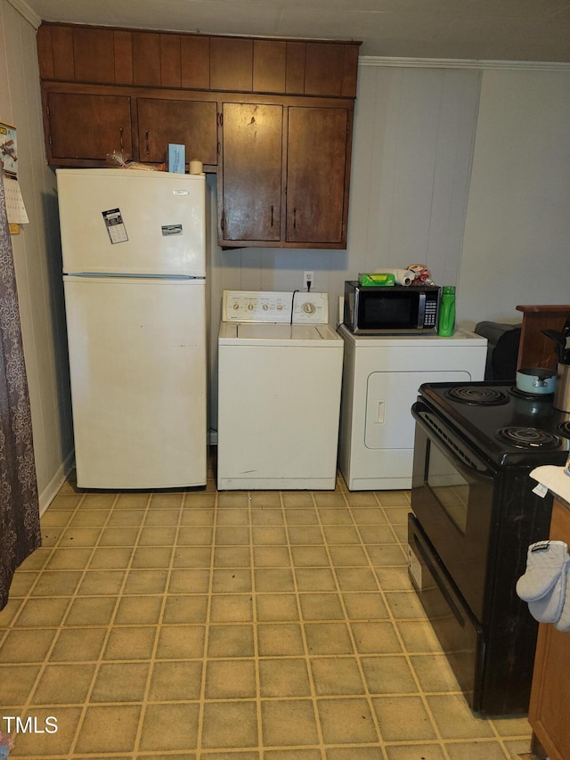 411 W Raleigh St, Siler City, NC 27344 - kitchen featuring freestanding refrigerator, stainless steel microwave, electric range, separate washer and dryer, and ornamental molding