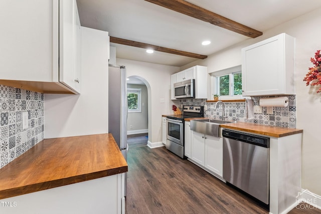 309 E End Ave, Durham, NC 27703 - kitchen with stainless steel appliances, wooden counters, arched walkways, beam ceiling, and white cabinets