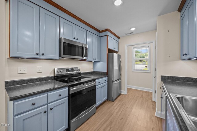 200 Cornerstone Dr, Franklinton, NC 27525 - kitchen with appliances with stainless steel finishes, dark countertops, light wood-type flooring, recessed lighting, and blue cabinets