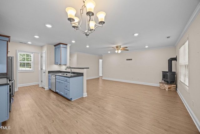 200 Cornerstone Dr, Franklinton, NC 27525 - kitchen with dark countertops, a wood stove, a ceiling fan, blue cabinets, and light wood-type flooring