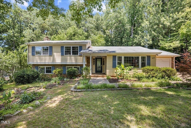 619 Ashe Ave, Cary, NC 27511 - split level home with an attached garage, a chimney, and a front yard