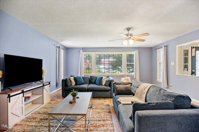 619 Ashe Ave, Cary, NC 27511 - living area featuring a textured ceiling, wood finished floors, and a ceiling fan