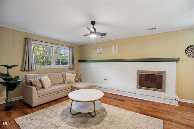 619 Ashe Ave, Cary, NC 27511 - living room with a ceiling fan, wood finished floors, crown molding, and a fireplace