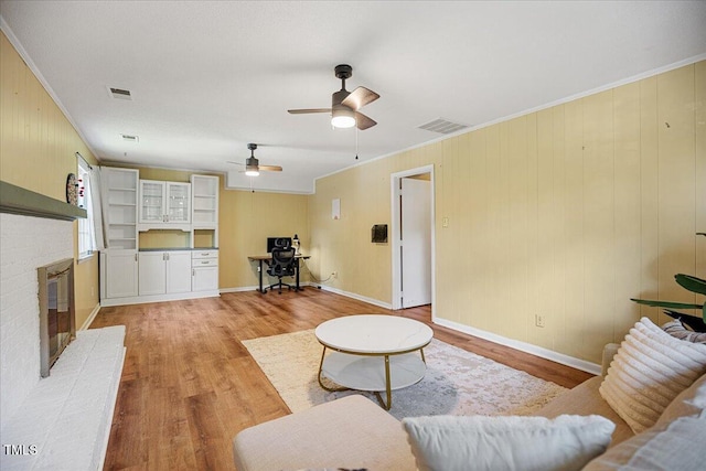 619 Ashe Ave, Cary, NC 27511 - living room with light wood-style flooring, ornamental molding, a desk, a brick fireplace, and a ceiling fan