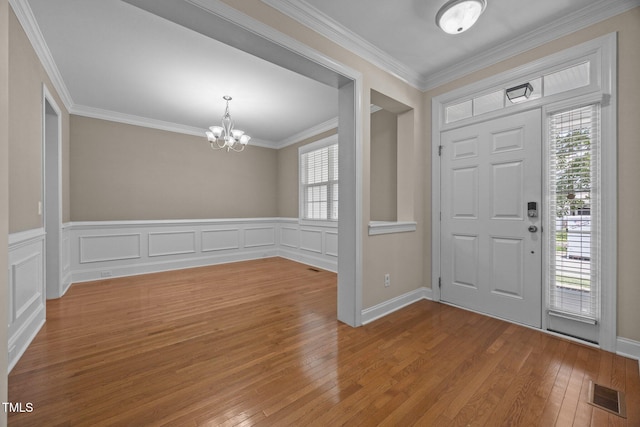 1012 Palace Garden Way, Raleigh, NC 27603 - entrance foyer featuring a chandelier, hardwood / wood-style floors, crown molding, and a wainscoted wall