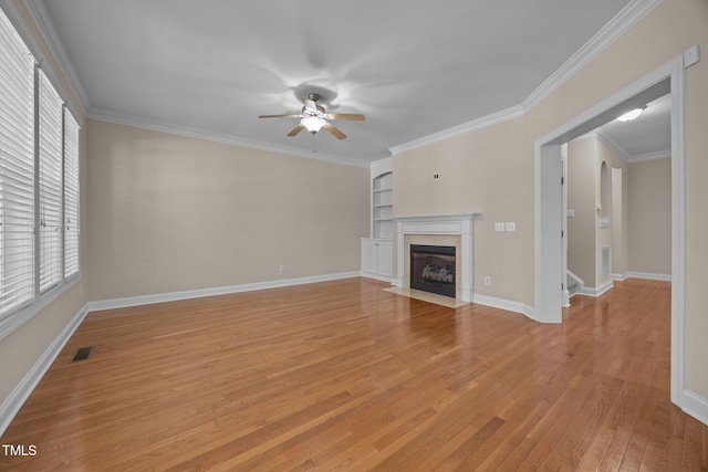 1012 Palace Garden Way, Raleigh, NC 27603 - unfurnished living room featuring ceiling fan, light wood-style floors, a fireplace with flush hearth, ornamental molding, and built in shelves