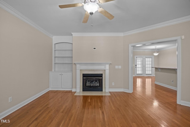 1012 Palace Garden Way, Raleigh, NC 27603 - unfurnished living room featuring a fireplace with flush hearth, ornamental molding, wood finished floors, ceiling fan, and built in shelves