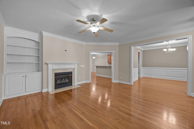 1012 Palace Garden Way, Raleigh, NC 27603 - unfurnished living room featuring a ceiling fan, a premium fireplace, a chandelier, built in shelves, and wood finished floors