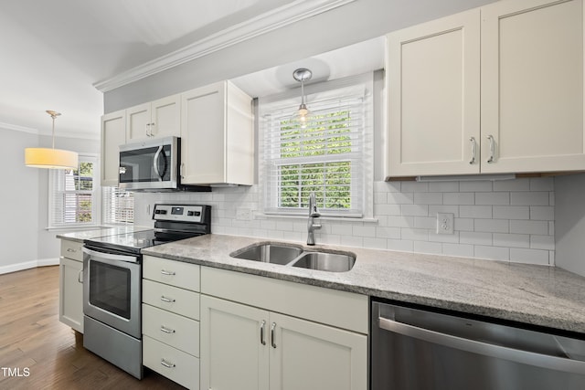 405 E Millbrook Rd, Raleigh, NC 27609 - kitchen featuring appliances with stainless steel finishes, crown molding, white cabinetry, tasteful backsplash, and light stone countertops