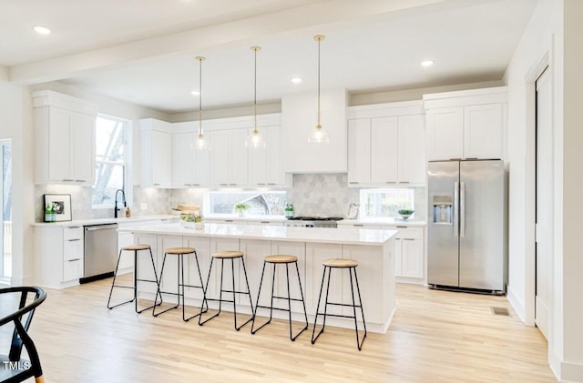 322 S Dixon Ave Unit R, Cary, NC 27511 - kitchen with appliances with stainless steel finishes, a center island, a kitchen bar, light wood-style floors, and recessed lighting