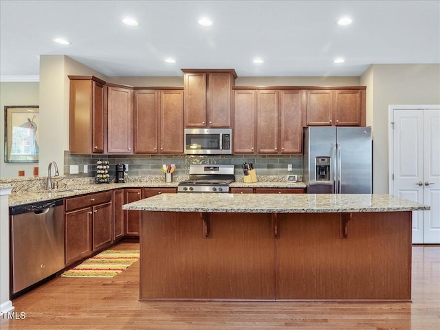 215 Brier Summit Pl, Durham, NC 27703 - kitchen featuring appliances with stainless steel finishes, light stone counters, backsplash, light wood-style floors, and crown molding