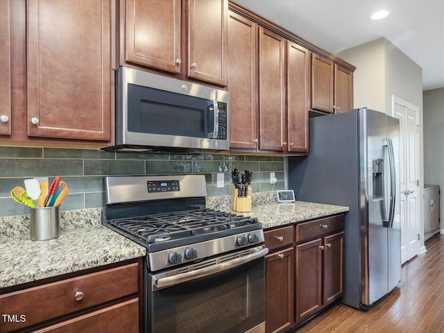 215 Brier Summit Pl, Durham, NC 27703 - kitchen featuring appliances with stainless steel finishes, wood finished floors, backsplash, light stone counters, and recessed lighting