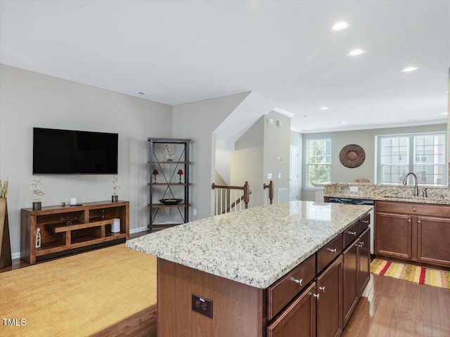 215 Brier Summit Pl, Durham, NC 27703 - kitchen with light stone countertops, a center island, wood finished floors, recessed lighting, and dishwasher