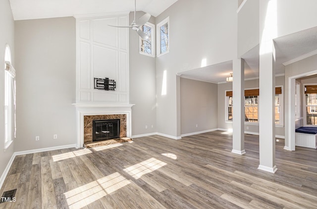 112 Solstice Cir, Cary, NC 27513 - unfurnished living room with high vaulted ceiling, ceiling fan, a high end fireplace, and wood finished floors