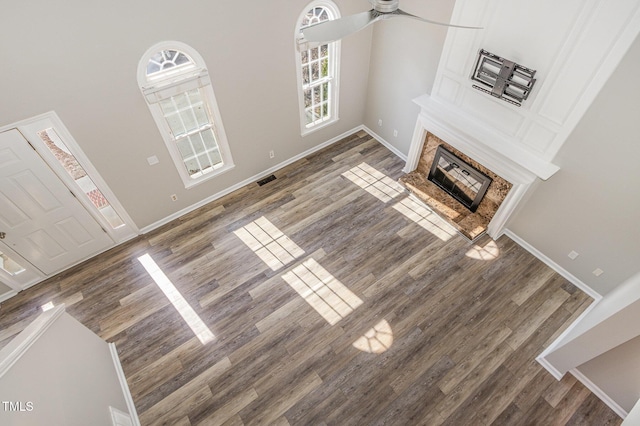 112 Solstice Cir, Cary, NC 27513 - unfurnished living room featuring a ceiling fan, wood finished floors, a fireplace, and a high ceiling