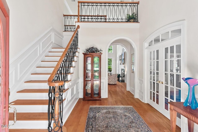 3606 Dairy Pond Pl, Durham, NC 27705 - entrance foyer with french doors, arched walkways, wood finished floors, a decorative wall, and stairway