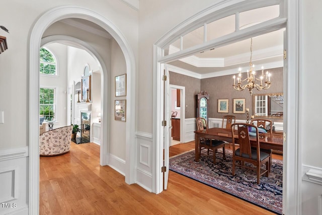 3606 Dairy Pond Pl, Durham, NC 27705 - dining area featuring light wood-style flooring, a chandelier, arched walkways, wainscoting, and ornamental molding