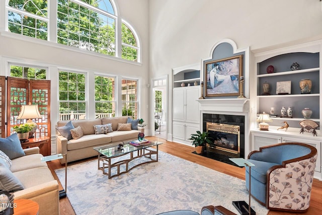 3606 Dairy Pond Pl, Durham, NC 27705 - living room featuring wood finished floors, a fireplace with flush hearth, a high ceiling, and built in features
