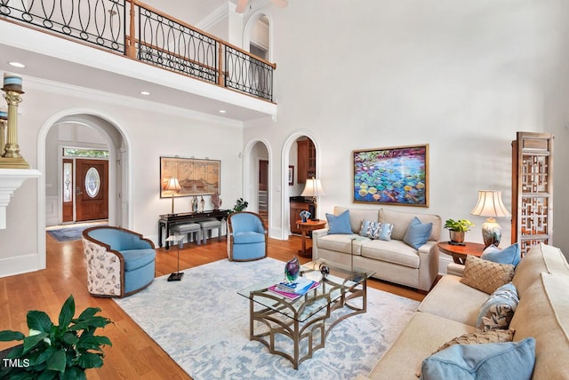 3606 Dairy Pond Pl, Durham, NC 27705 - living area featuring arched walkways, a towering ceiling, wood finished floors, ornamental molding, and recessed lighting