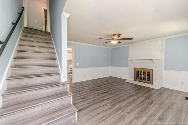 4101 Carson Dr, Sanford, NC 27332 - unfurnished living room with a ceiling fan, stairs, a brick fireplace, wood finished floors, and ornamental molding
