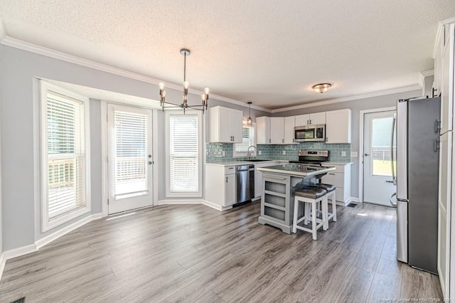 4101 Carson Dr, Sanford, NC 27332 - kitchen with stainless steel appliances, a textured ceiling, light wood-type flooring, a center island, and white cabinetry