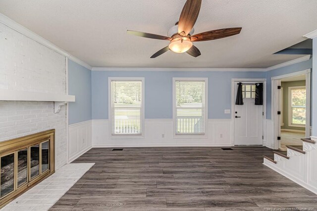 4101 Carson Dr, Sanford, NC 27332 - unfurnished living room featuring ceiling fan, a wainscoted wall, plenty of natural light, ornamental molding, and wood finished floors