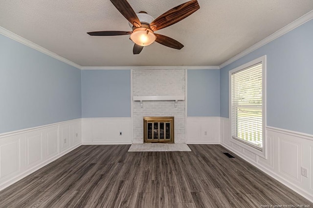 4101 Carson Dr, Sanford, NC 27332 - unfurnished living room with ceiling fan, a fireplace, dark wood-type flooring, a wainscoted wall, and a textured ceiling