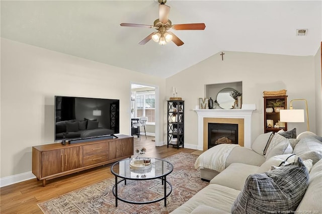 167 Westminster Dr, Raeford, NC 28376 - living area with a ceiling fan, lofted ceiling, light wood-style flooring, and a tiled fireplace