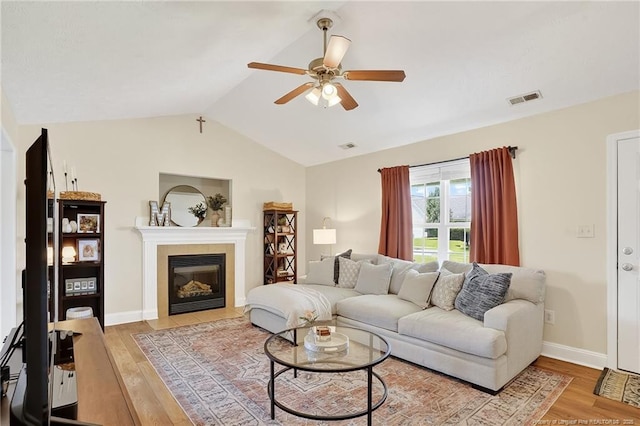 167 Westminster Dr, Raeford, NC 28376 - living room featuring ceiling fan, light wood-style flooring, lofted ceiling, and a fireplace with flush hearth