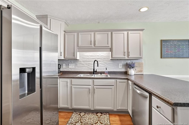 167 Westminster Dr, Raeford, NC 28376 - kitchen featuring stainless steel appliances, a textured ceiling, dark countertops, a peninsula, and backsplash