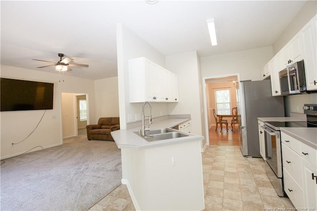 130 Pinecone Ct, Seven Lakes, NC 27376 - kitchen featuring appliances with stainless steel finishes, open floor plan, a peninsula, white cabinets, and light countertops