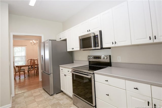 130 Pinecone Ct, Seven Lakes, NC 27376 - kitchen featuring appliances with stainless steel finishes, a chandelier, white cabinets, light countertops, and light floors