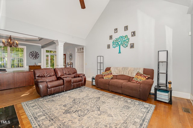 15 Cole Creek Way, Franklinton, NC 27525 - living room featuring decorative columns, wood finished floors, high vaulted ceiling, a ceiling fan, and a chandelier