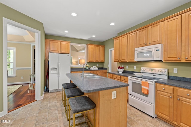 126 Captains Ct, Durham, NC 27712 - kitchen with white appliances, dark countertops, a center island with sink, a kitchen breakfast bar, and recessed lighting