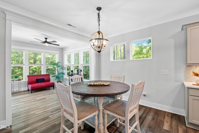 8341 Running Fern Way, Willow Springs, NC 27592 - dining space with dark wood-type flooring, a chandelier, crown molding, and ceiling fan