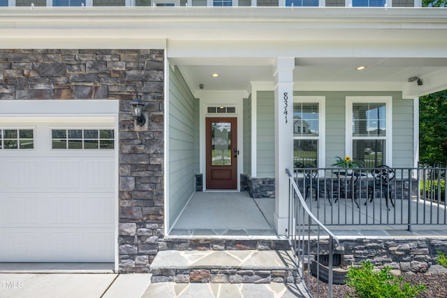 8341 Running Fern Way, Willow Springs, NC 27592 - view of exterior entry with stone siding, a garage, and covered porch