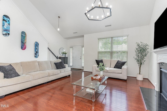 543 Callandale Ln, Durham, NC 27703 - living area featuring wood finished floors, a premium fireplace, high vaulted ceiling, a chandelier, and stairs