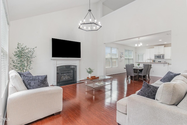 543 Callandale Ln, Durham, NC 27703 - living area featuring a chandelier, a premium fireplace, dark wood-type flooring, and high vaulted ceiling