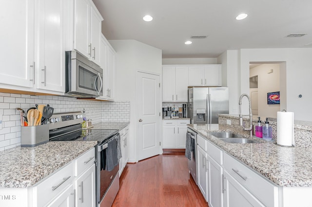 543 Callandale Ln, Durham, NC 27703 - kitchen with stainless steel appliances, dark wood finished floors, white cabinets, an island with sink, and backsplash