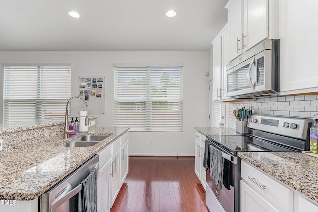 543 Callandale Ln, Durham, NC 27703 - kitchen with appliances with stainless steel finishes, dark wood-style floors, white cabinetry, decorative backsplash, and recessed lighting