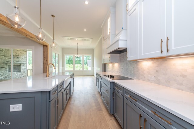 0 Bluestone Ct Lot 22R, Chapel Hill, NC 27514 - kitchen with black electric cooktop, light wood-style floors, tasteful backsplash, custom range hood, and white cabinets