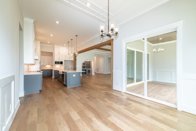 0 Bluestone Ct Lot 22R, Chapel Hill, NC 27514 - kitchen featuring a chandelier, open floor plan, stainless steel microwave, light countertops, and backsplash