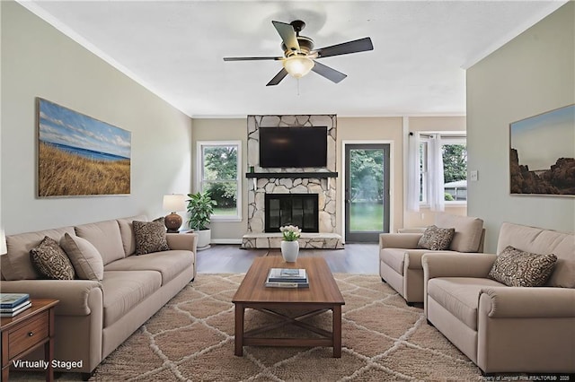 2012 Cobblestone Pl, Fayetteville, NC 28304 - living area featuring wood finished floors, a stone fireplace, ornamental molding, plenty of natural light, and ceiling fan