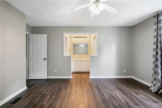 2012 Cobblestone Pl, Fayetteville, NC 28304 - unfurnished bedroom with dark wood-style floors, ensuite bath, and ceiling fan
