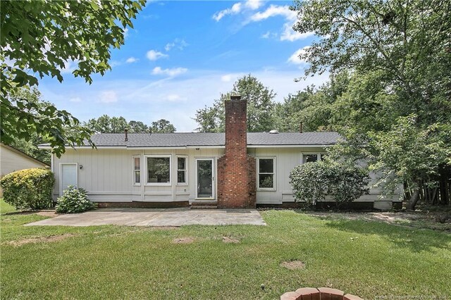 2012 Cobblestone Pl, Fayetteville, NC 28304 - rear view of house featuring a patio area, a lawn, and a chimney